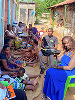 A group of people gathered outside in a Kenyan village