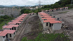 Two rows of small cinder block homes with red roofs in Mexico