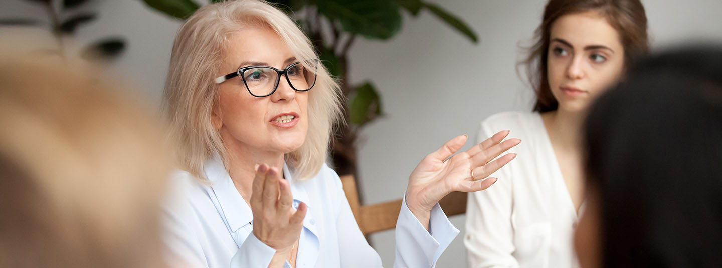 Woman leading a staff meeting with three others