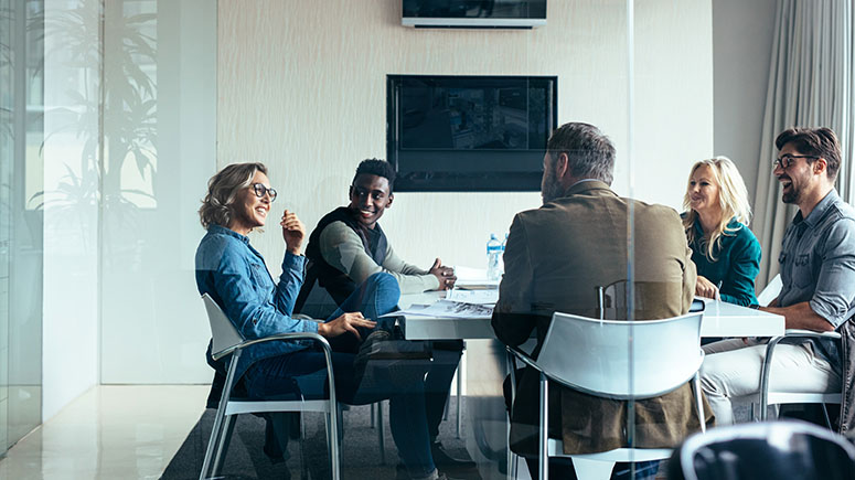 Five people in a conference room talking