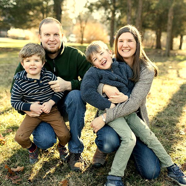 Man and woman holding two young sons outdoors